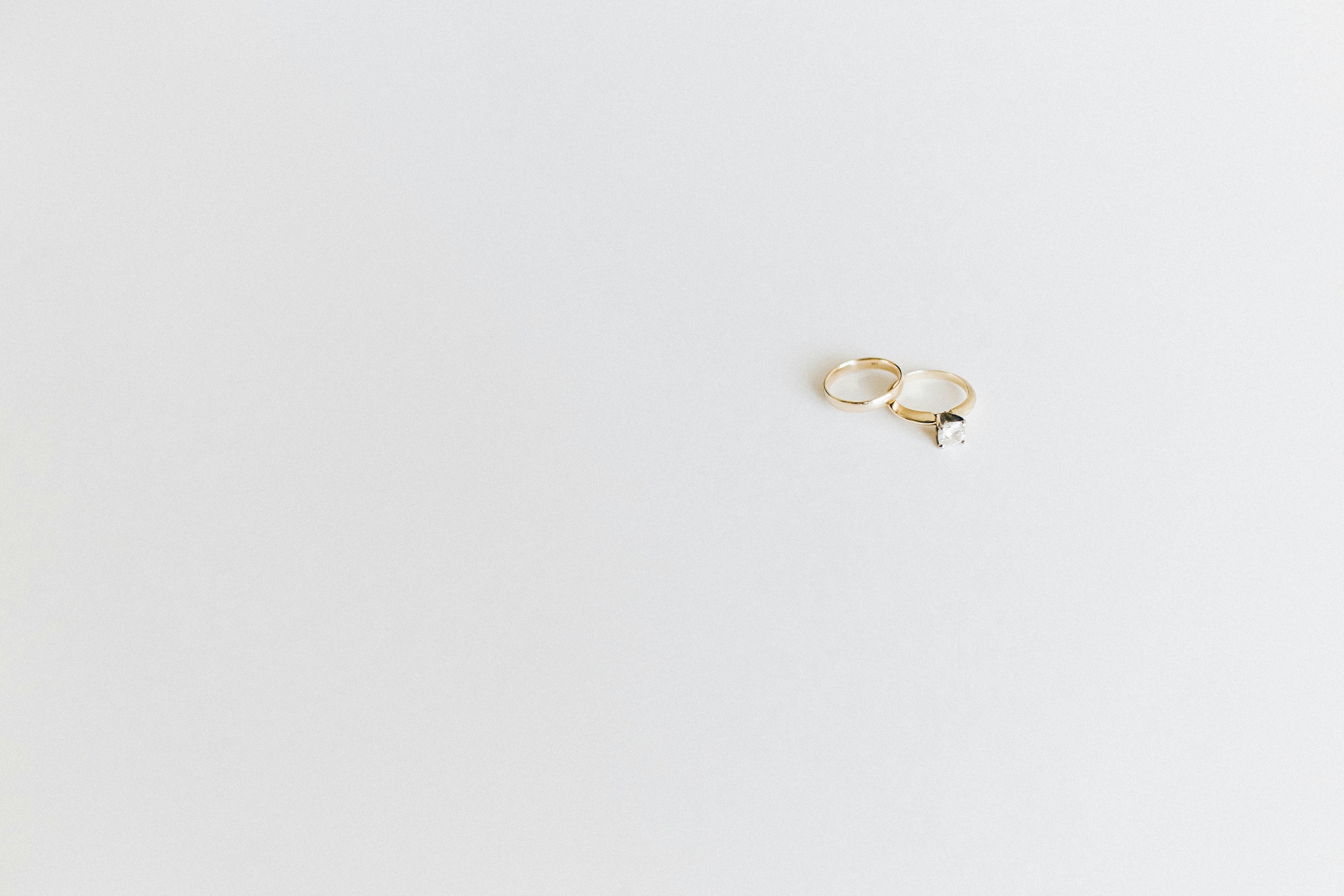 Two gold rings on an ivory surface